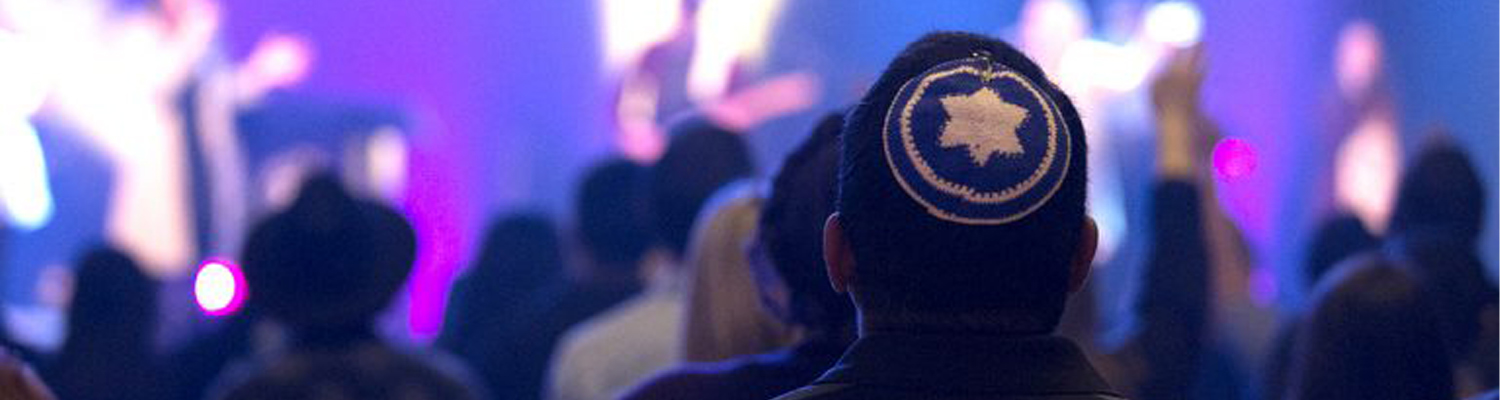 Messianic Jewish Studies banner Messianic Jewish Studies: A man in a kippah of the Star of David stands in a crowd during worship.